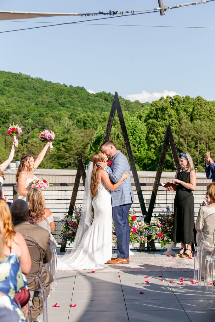 A couple during their first kiss at their wedding 