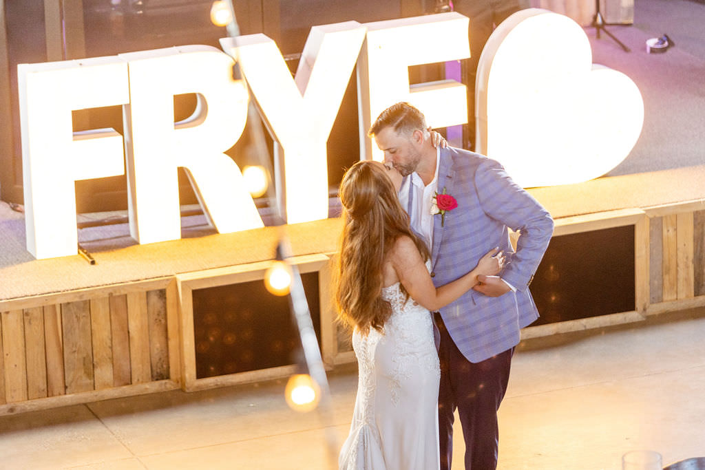 A newlywed couple kissing during their first dance 