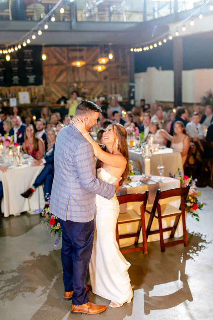 A wedding couple during their first dance with their guests watching. 