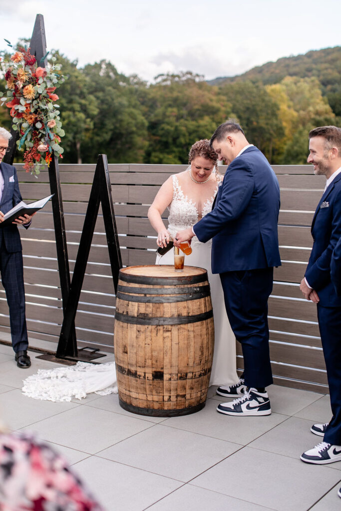 A wedding couple pouring two pints of beer into one during their ceremony 