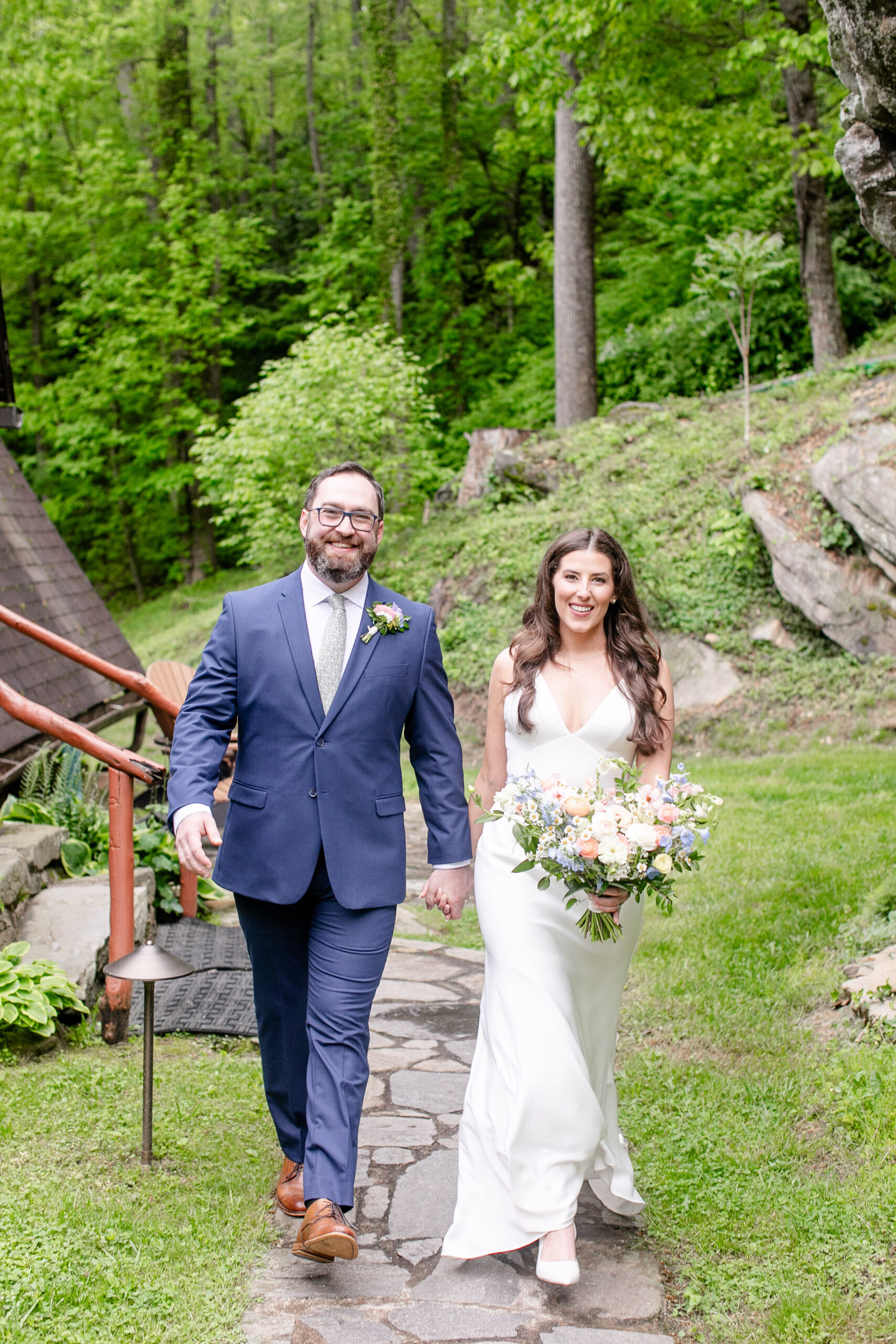 Bride and groom holding hands walking towards the camera