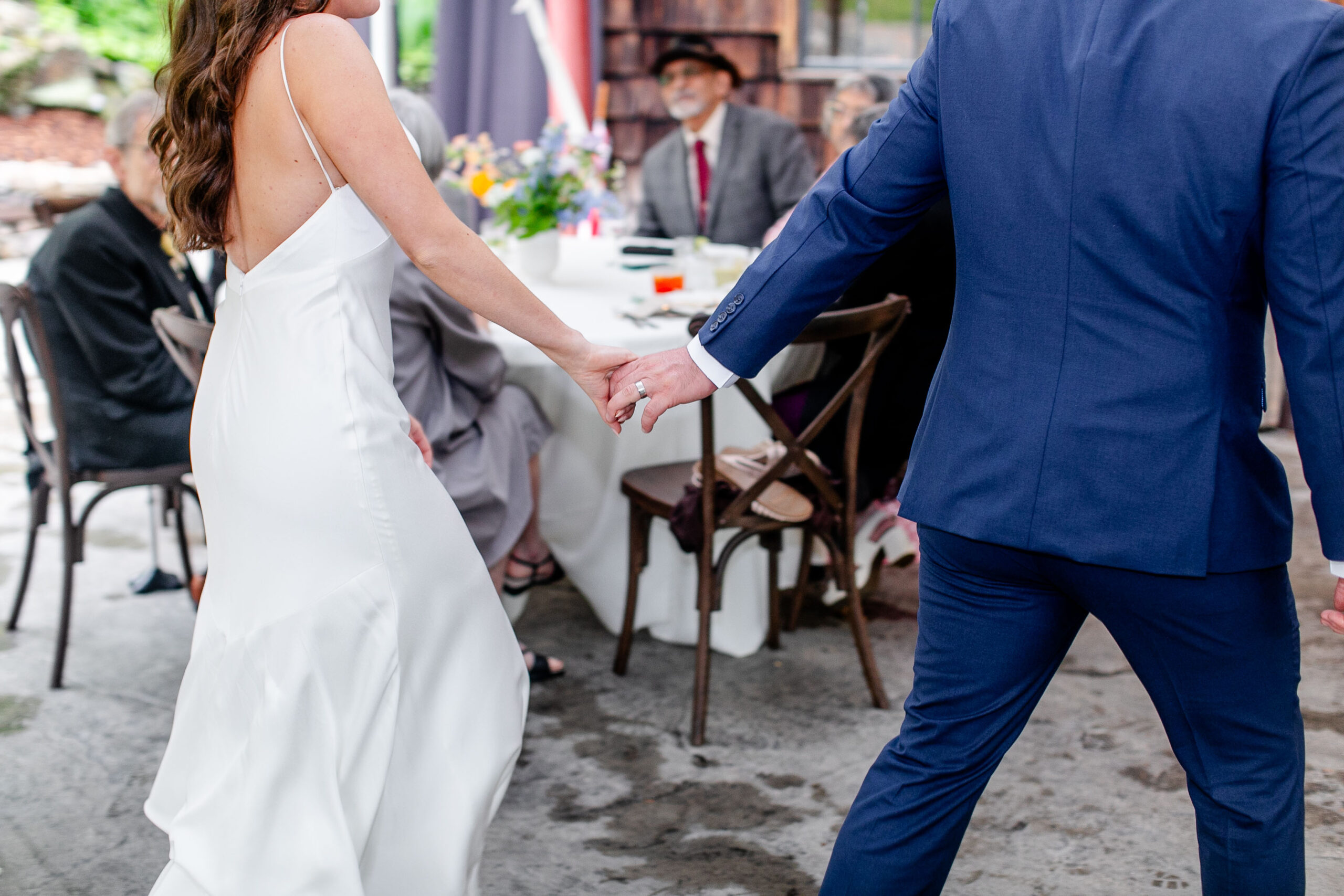 close up of bride and groom holding hands