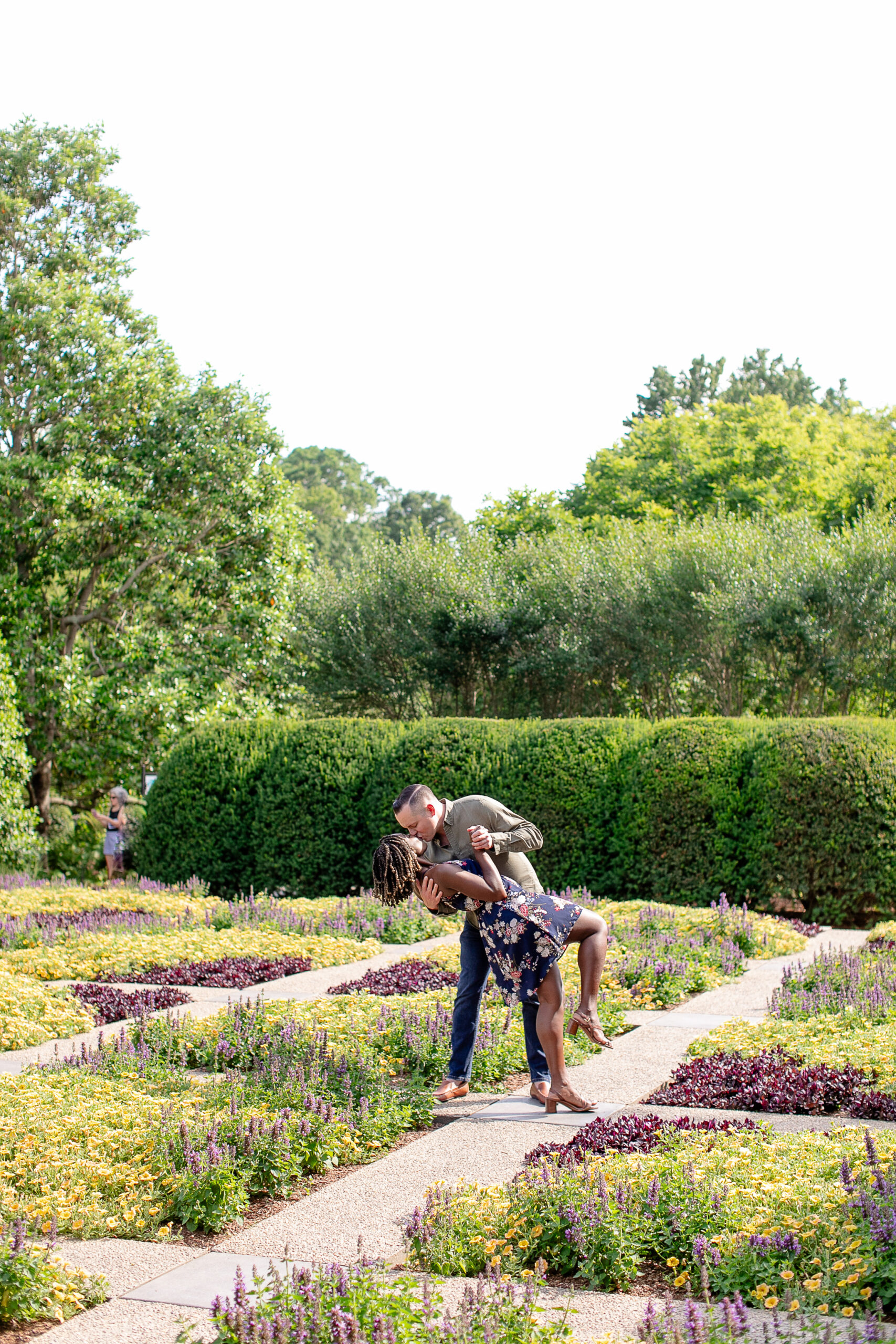 a man and a woman giving each other a kiss in a garden