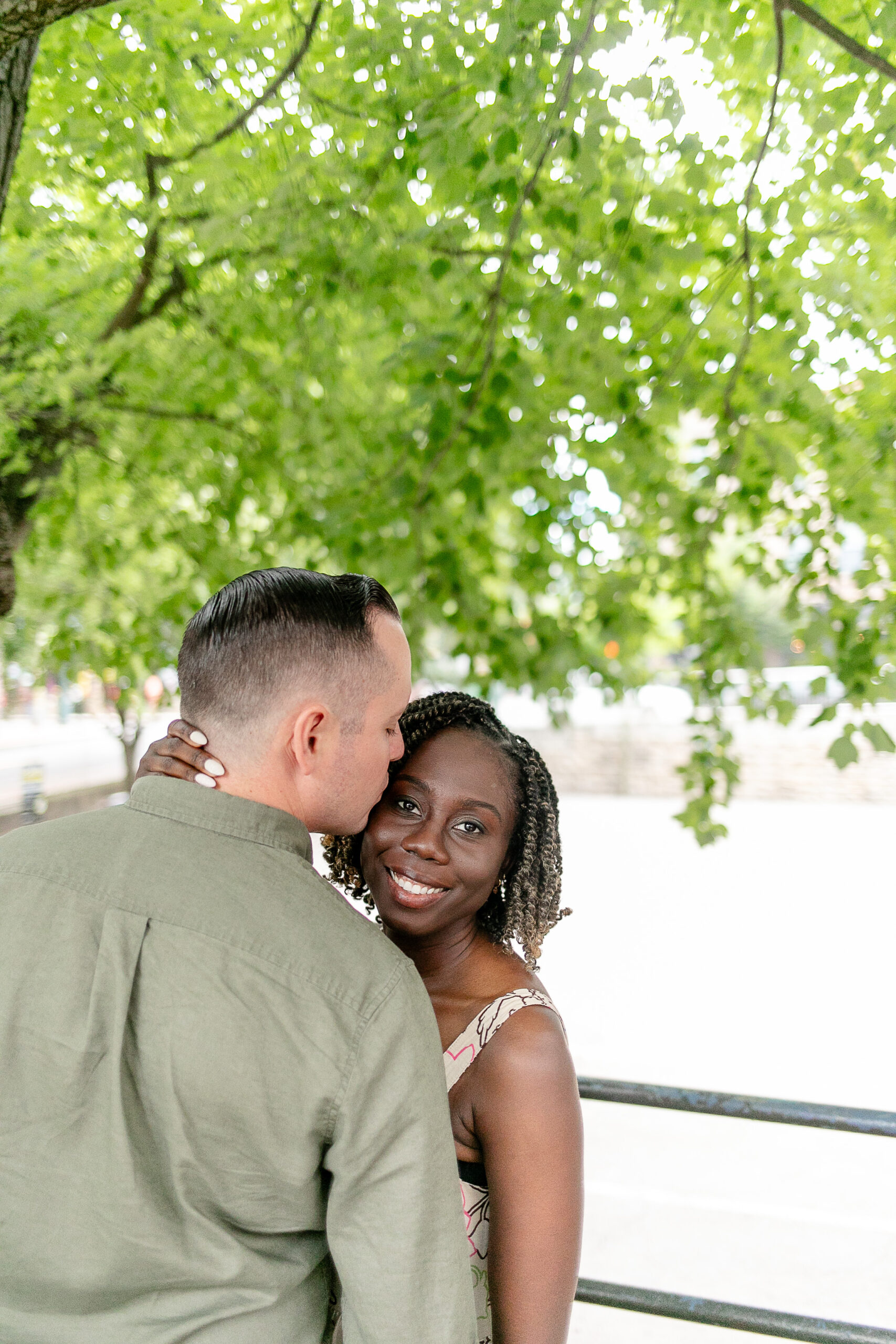 a woman and a man together with the man giving the woman a kiss on the forehead 