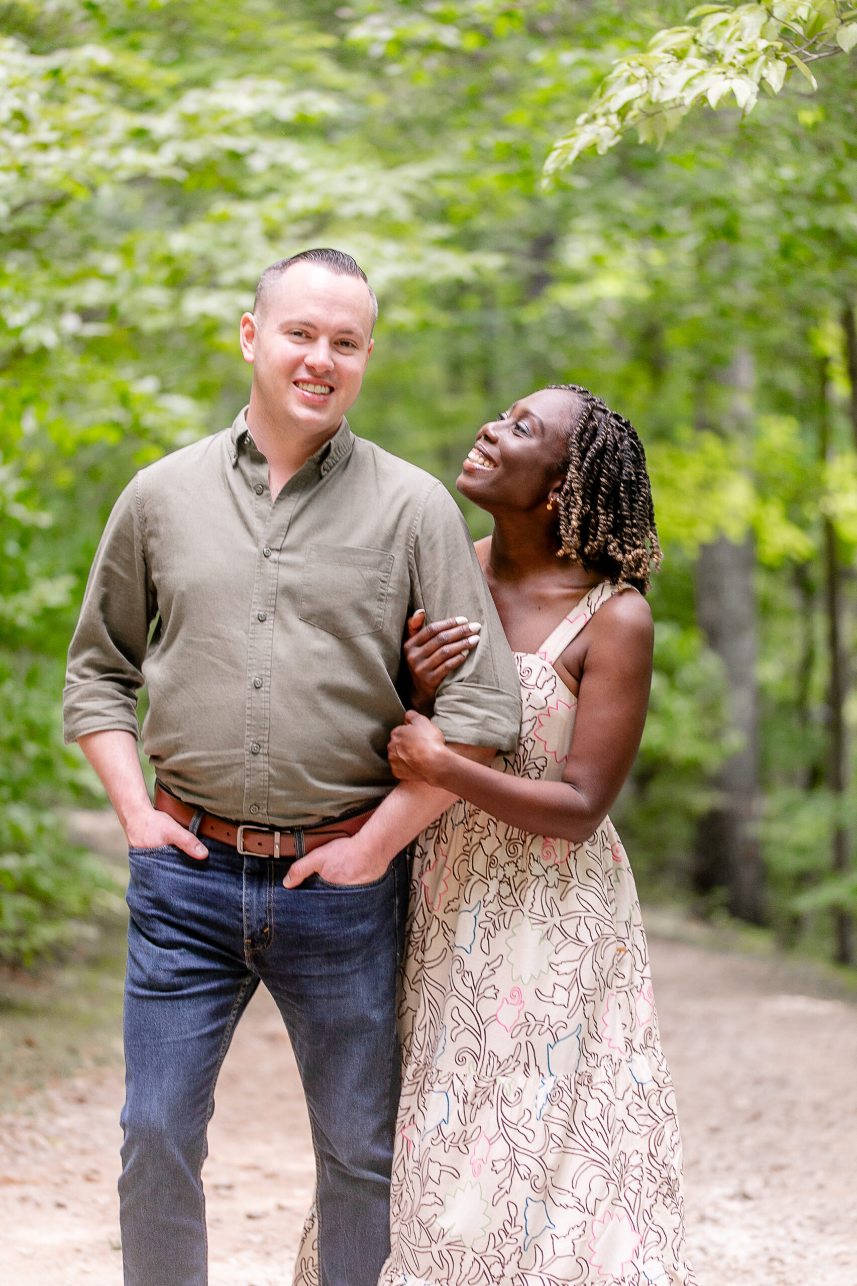 man is looking towards the camera while woman grabs his arm and looks towards him 