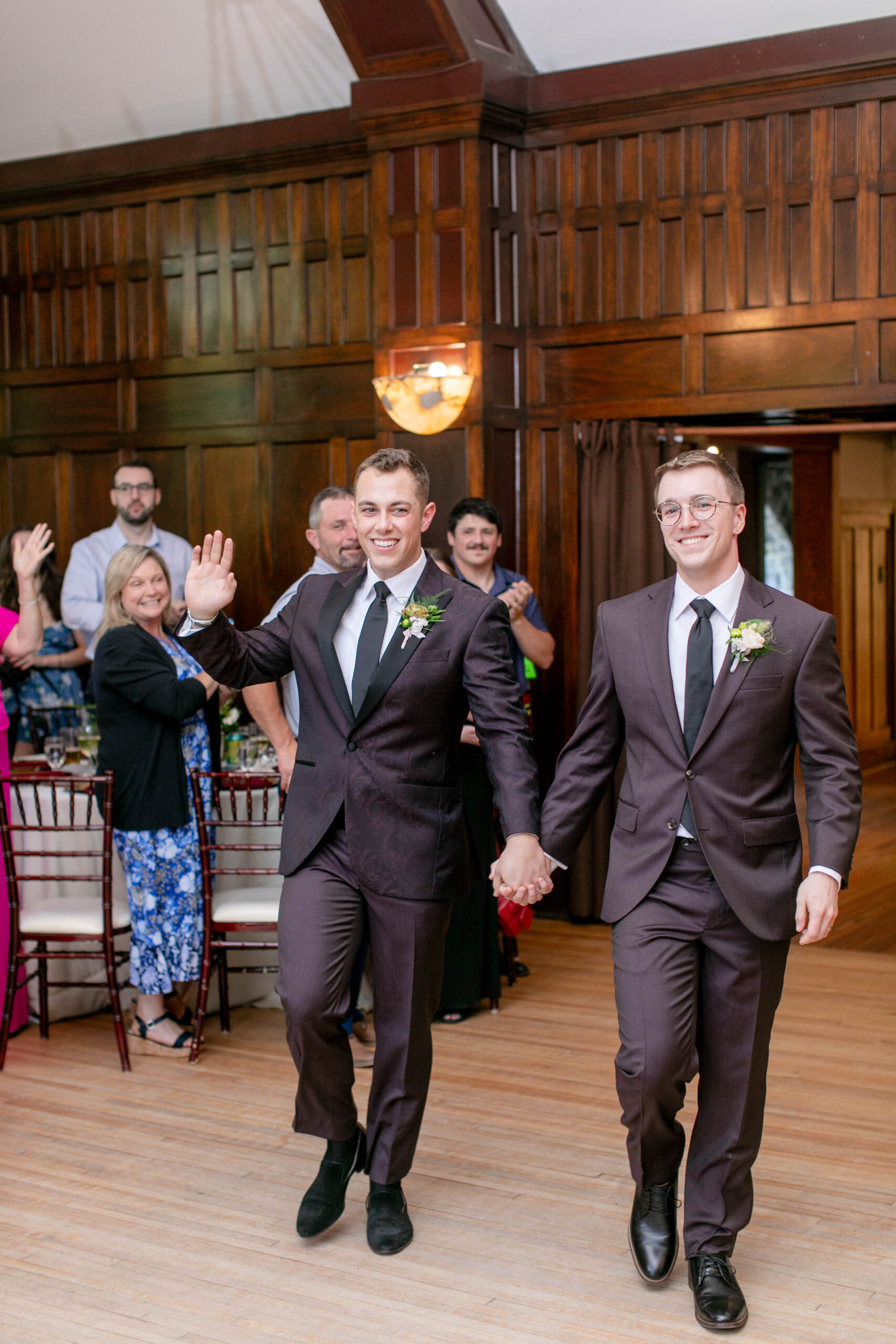 two men who just got married entering the doors to their wedding reception