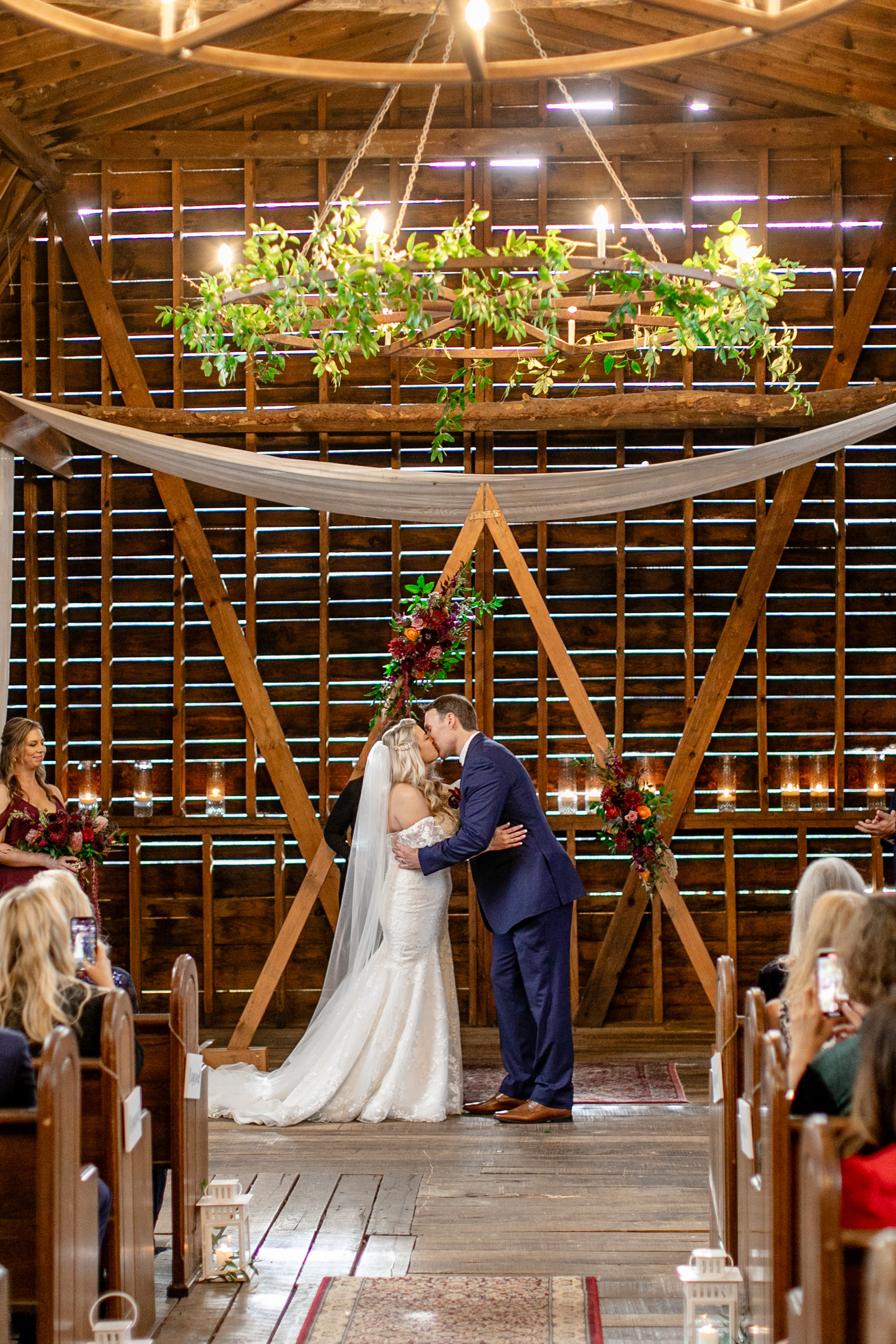 groom and bride kissing underneath a chandelier 