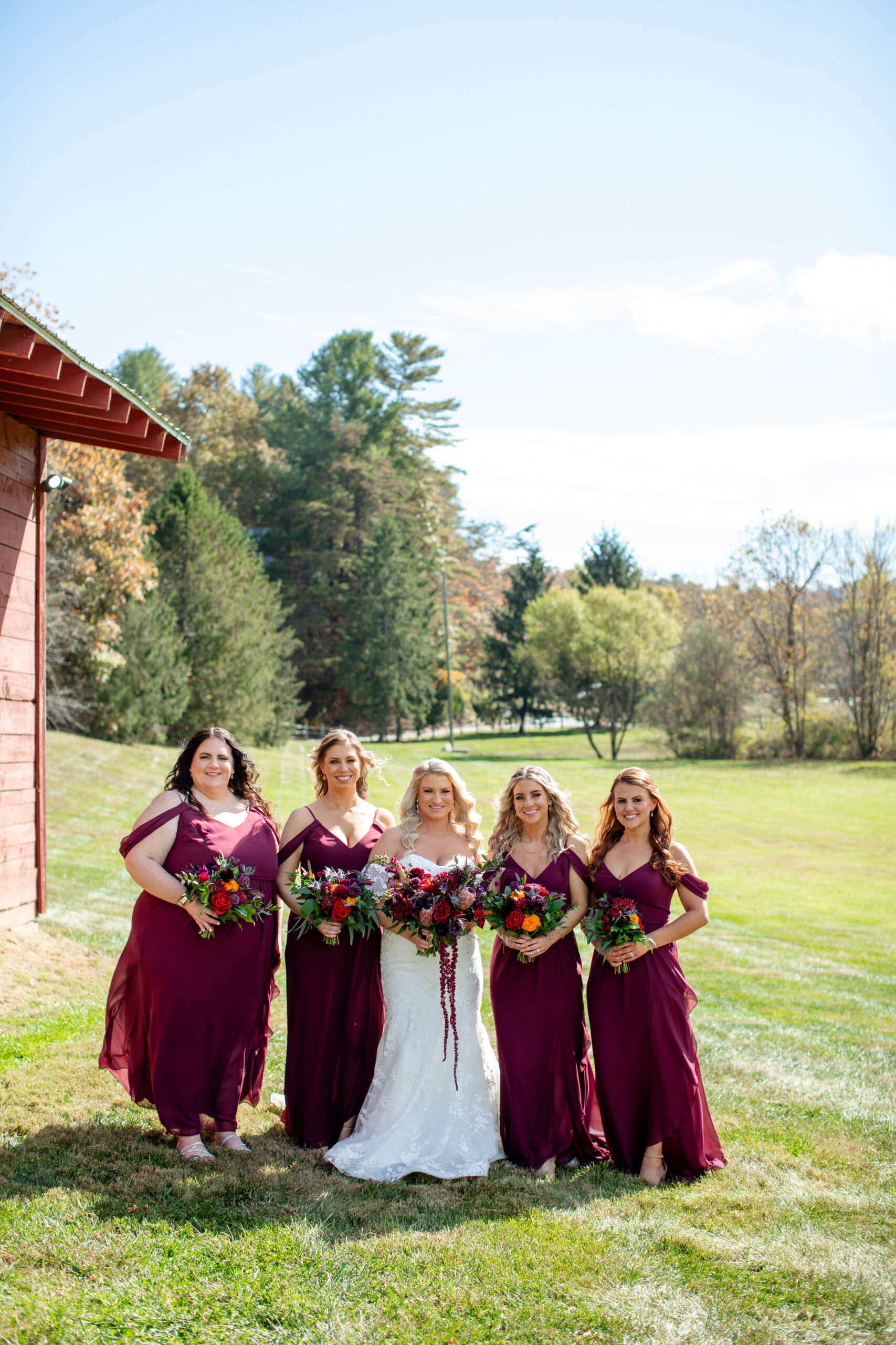 bridal party with bride and four bridesmaids in maroon dresses 