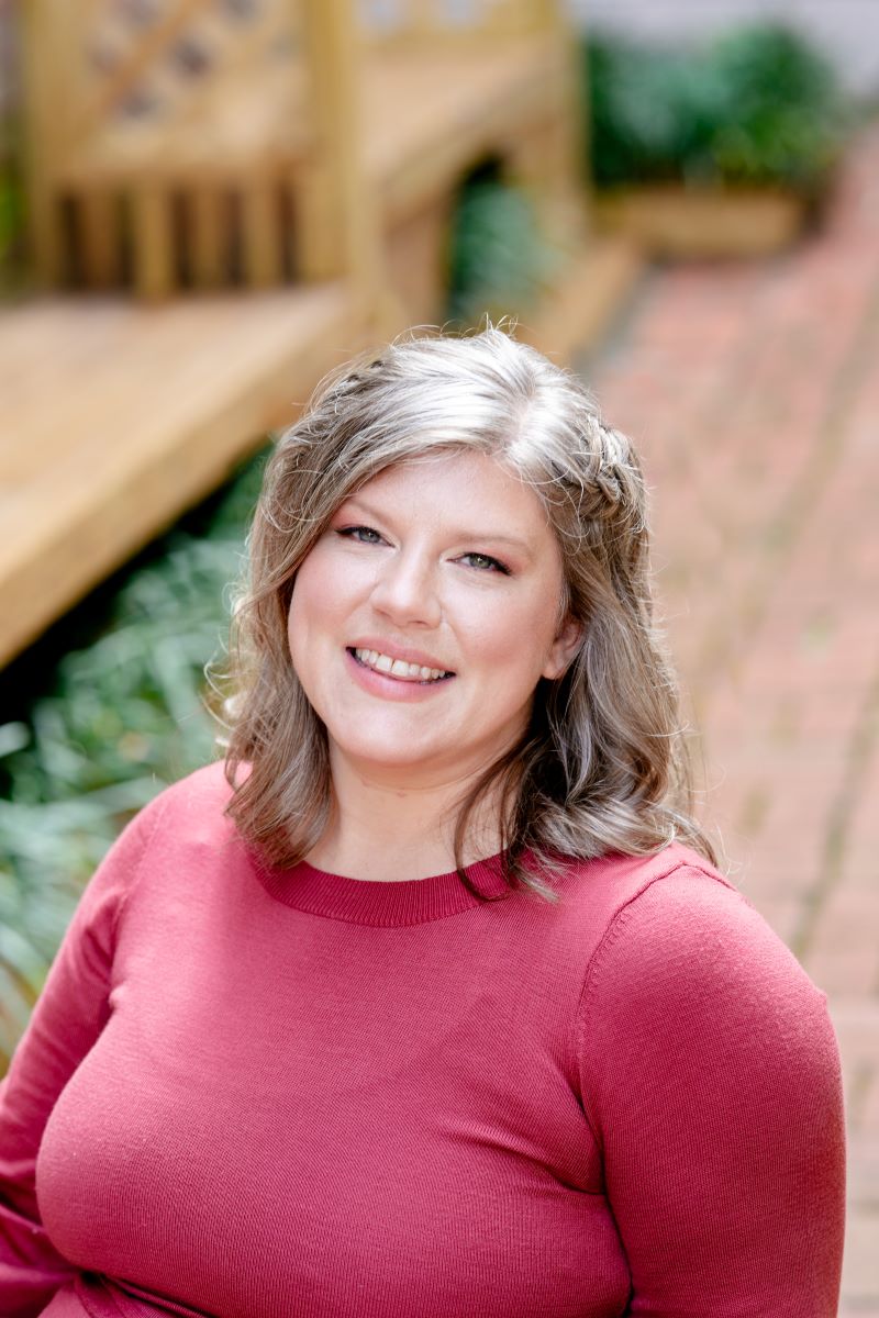 A woman in a red dress posing for a headshot