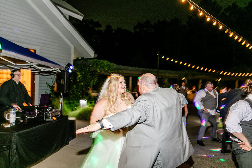 A wedding couple dancing in a courtyard during their wedding reception. 