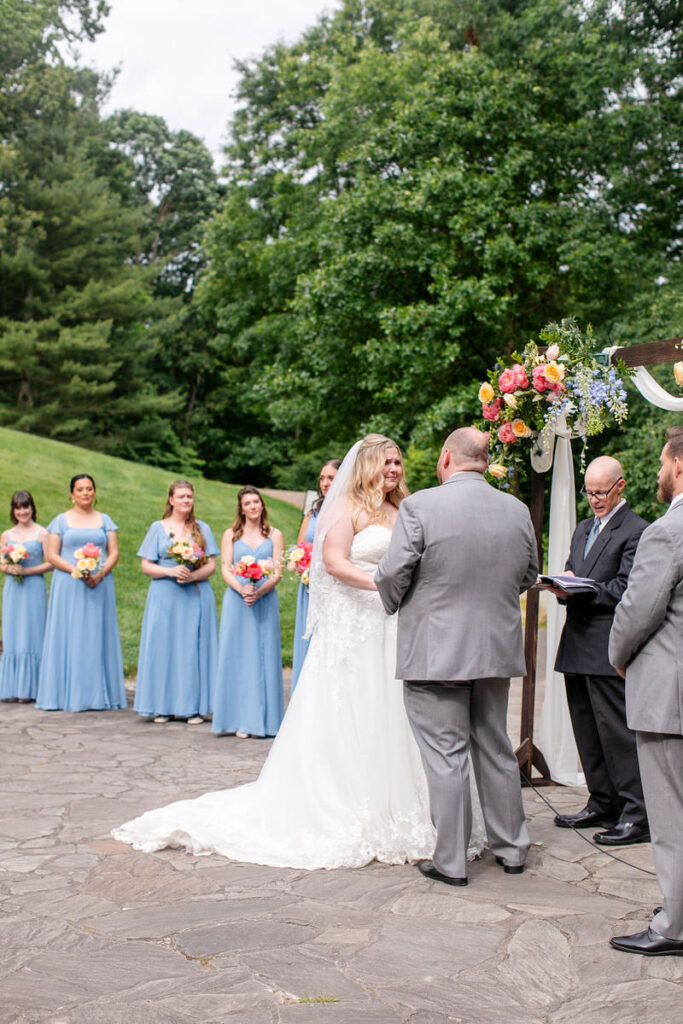 A couple holding hands as they say their vows during their wedding ceremony. 