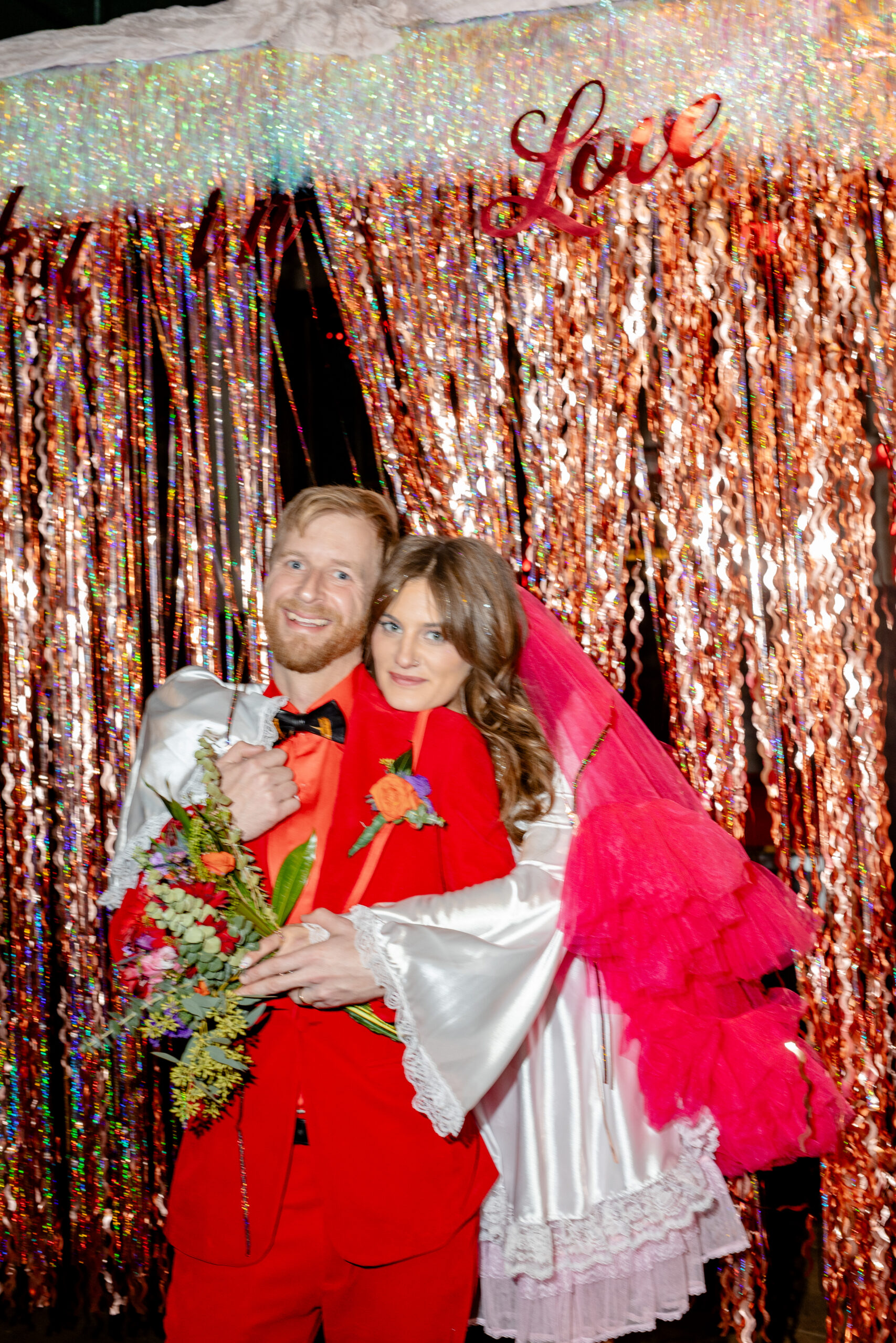 Modern trendy couple for a Las Vegas style elopement in Asheville North Carolina with DIY decor hot pink wedding veil on the bride and a groom dressed in all red