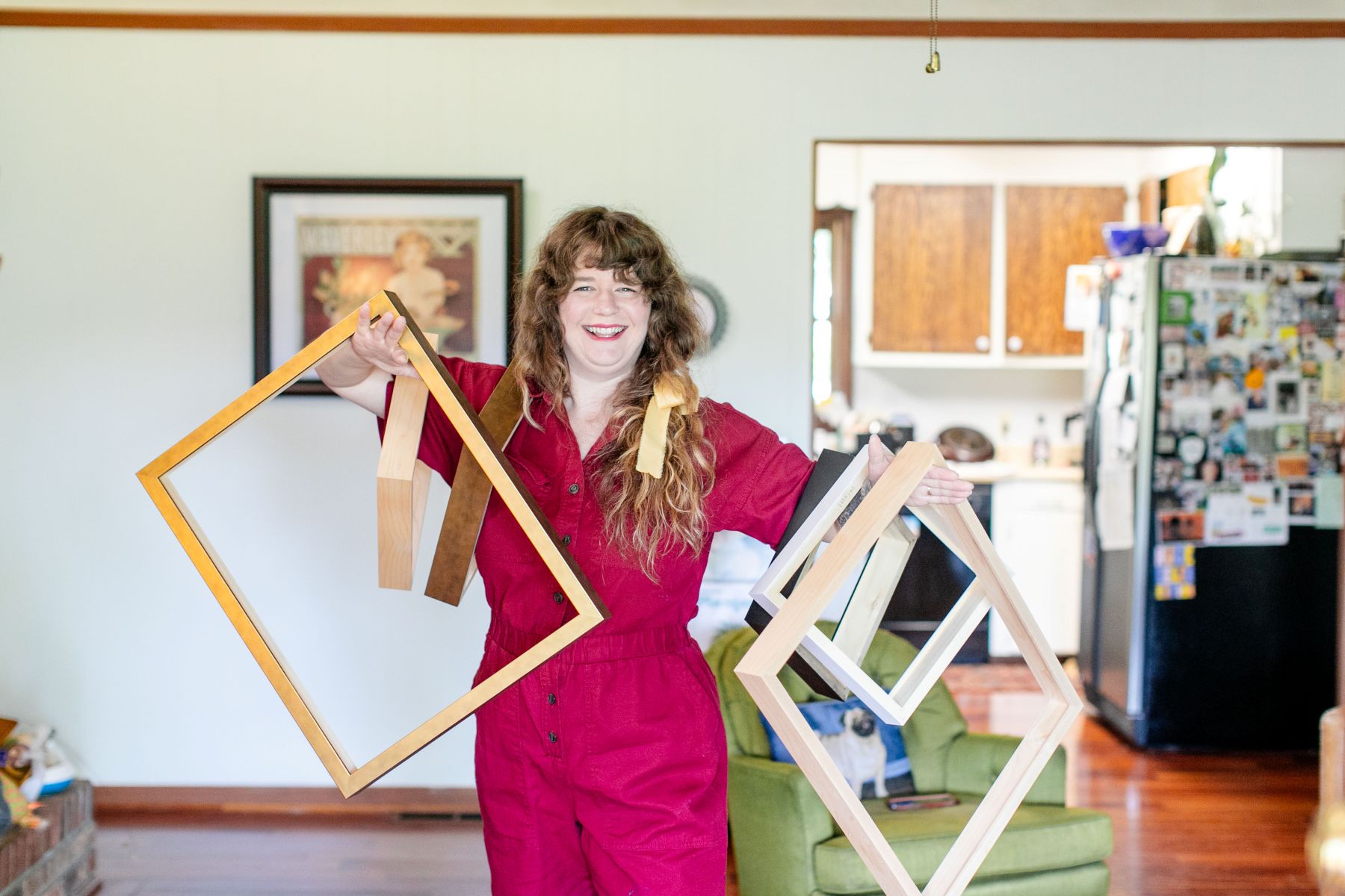 a woman holding up different sizes of wooden frames 