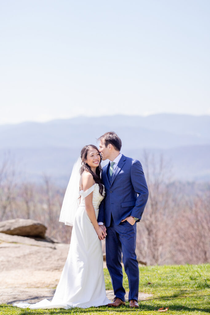 Bride and groom smiling during their Asheville elopement with Blue Ridge Mountains views behind them on a sunny day
