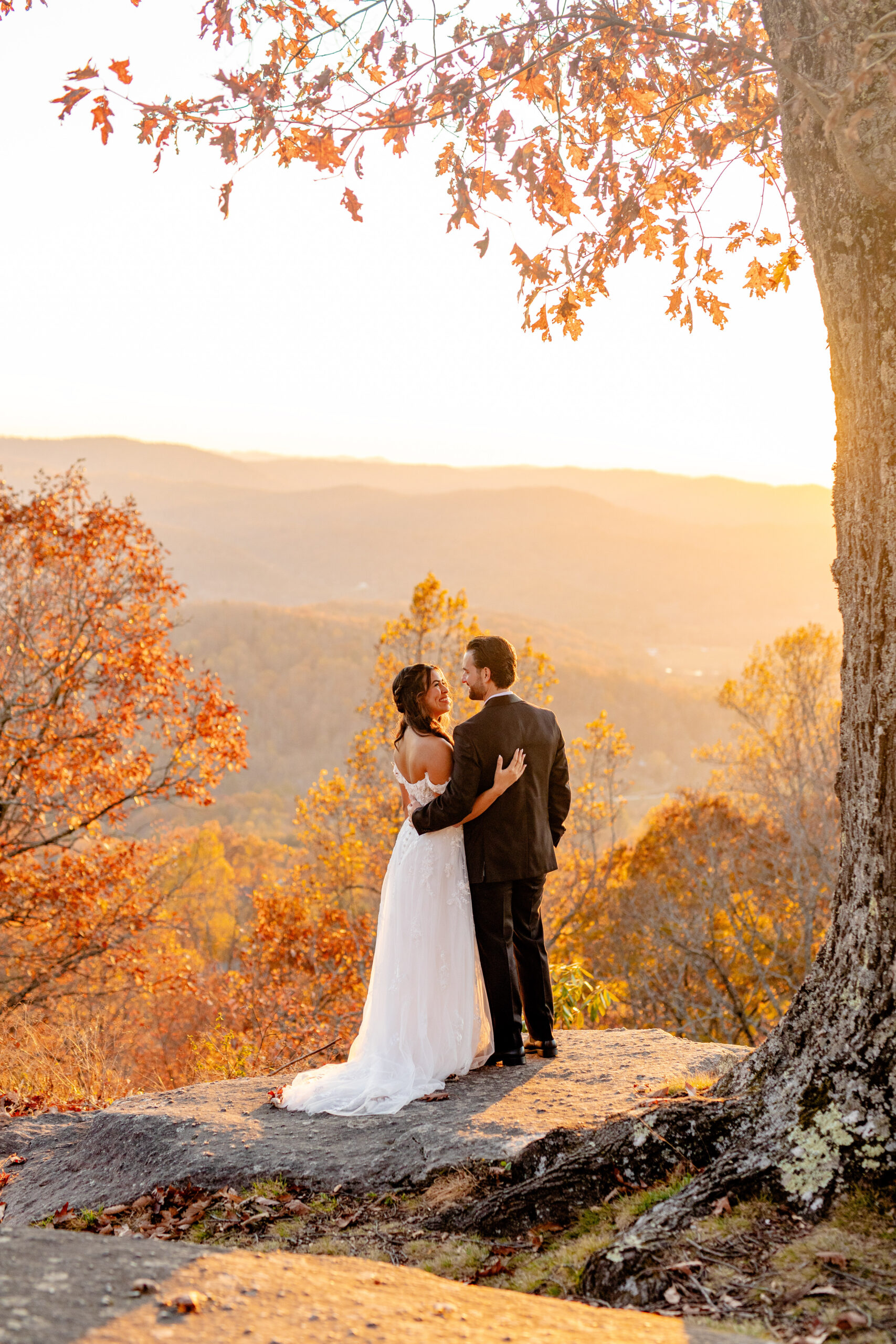 Asheville elopement couple standing together on a Blue Ridge Mountains overlook at sunset during their fall ceremony