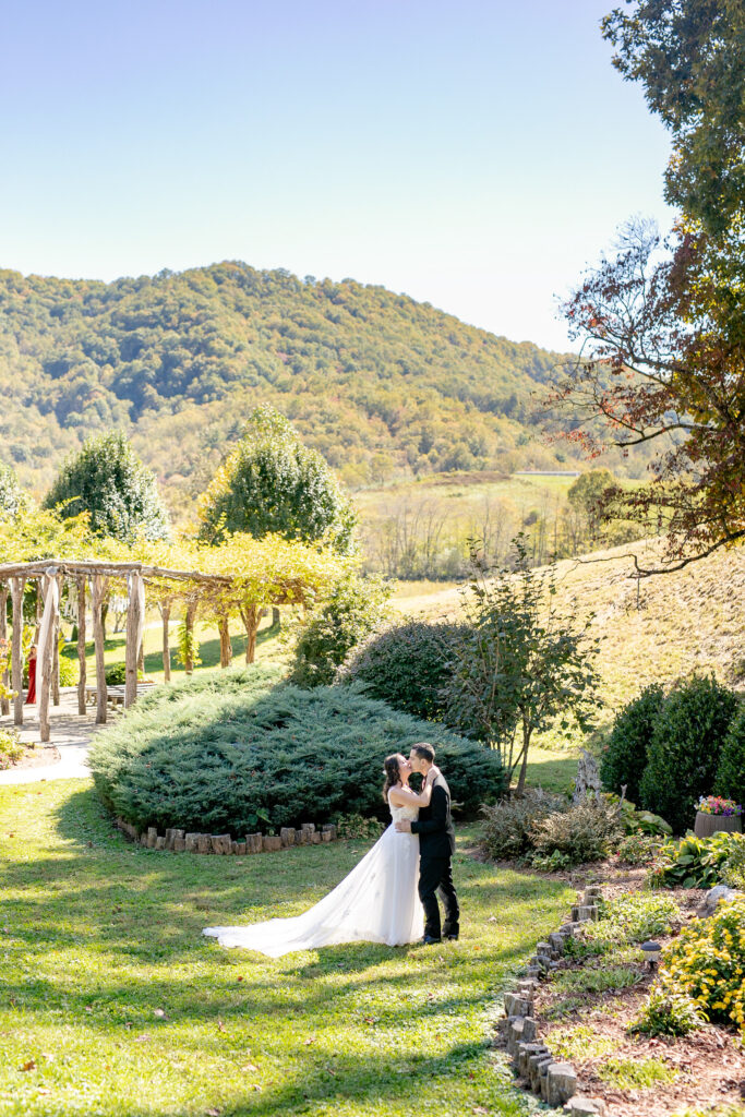 Bride and groom sharing a quiet moment during their Asheville elopement in a mountain valley surrounded by greenery and Blue Ridge views