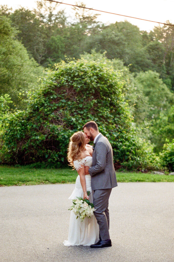 Bride and groom sharing a quiet kiss during their Homewood wedding in Asheville, North Carolina, photographed on film with soft natural light and greenery