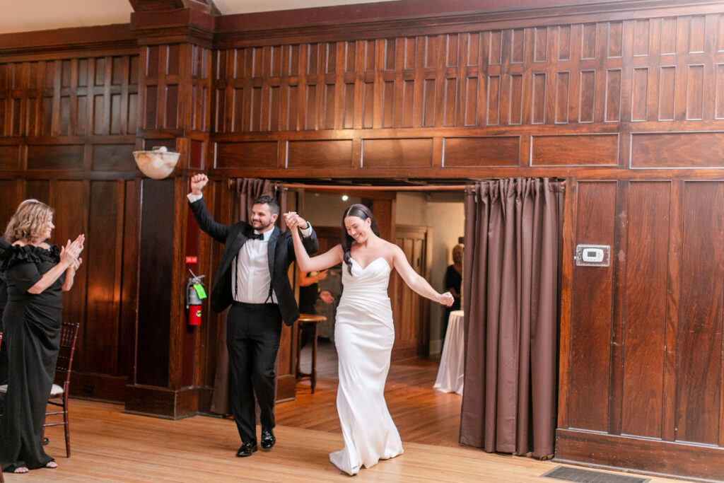 bride and groom making their grand entrance into their wedding reception at an elegant wood paneled venue in Asheville NC