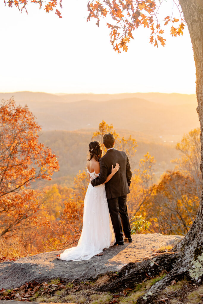 bride and groom overlooking fall foliage and Blue Ridge Mountain views during their Asheville NC wedding