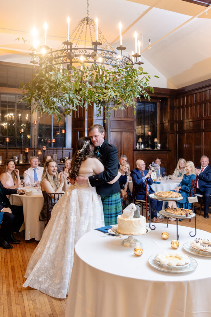 bride and groom sharing their first dance at an elegant indoor wedding reception in Asheville NC with chandelier and wood paneled walls