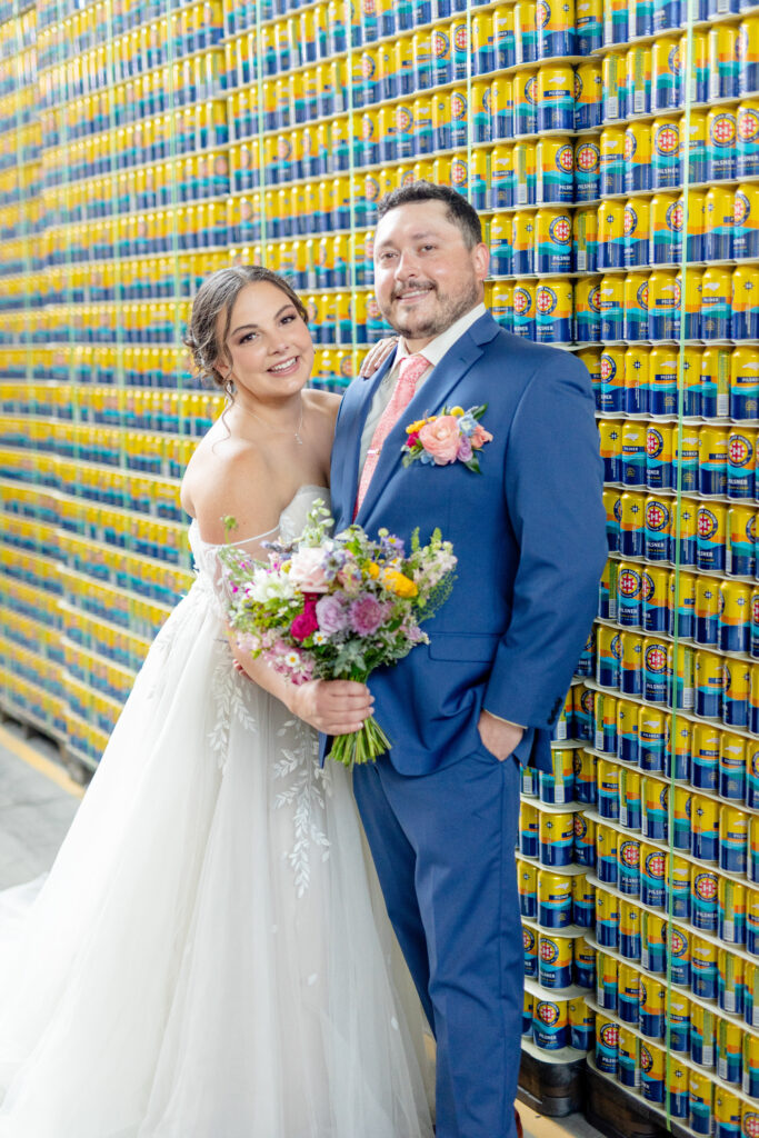 bride and groom wedding portraits in front of Highland Brewing pilsner can wall in Asheville NC